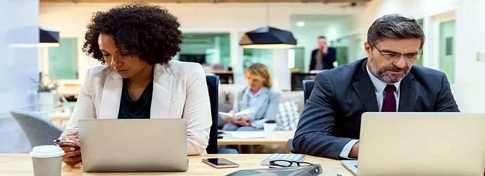 Colleagues working on laptops in a shared office