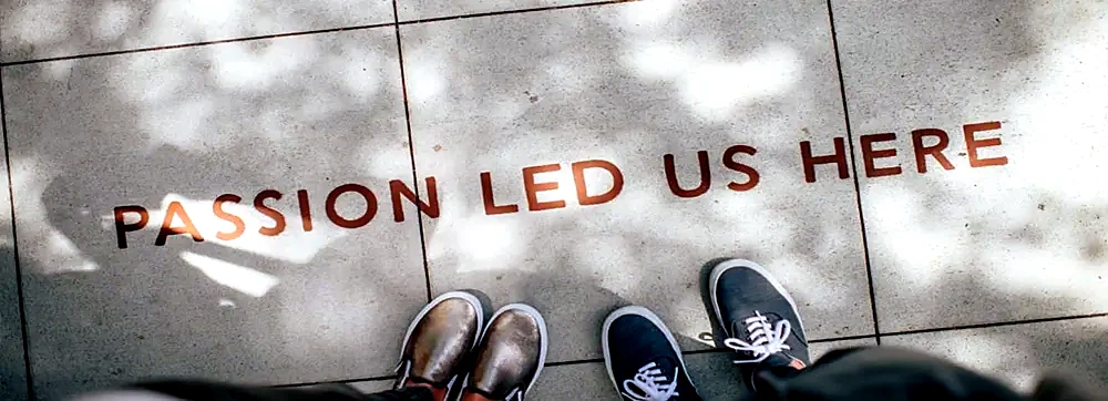 The words Passion Led Us Here painted on paving